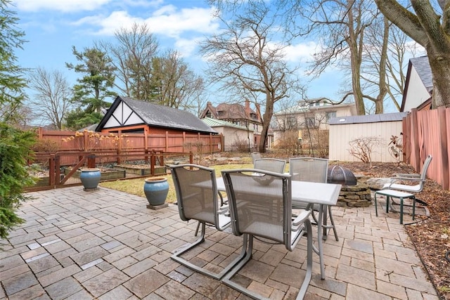 view of patio / terrace with outdoor dining space, an outdoor structure, and a fenced backyard