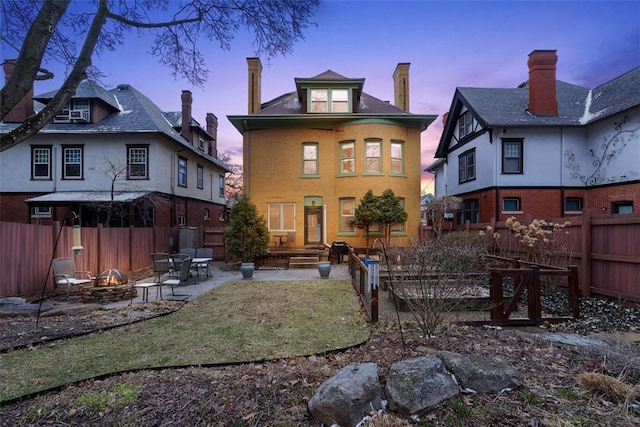 back of house featuring a patio area, fence private yard, and an outdoor fire pit