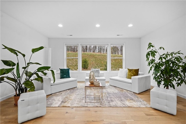 living area with recessed lighting, baseboards, and wood finished floors