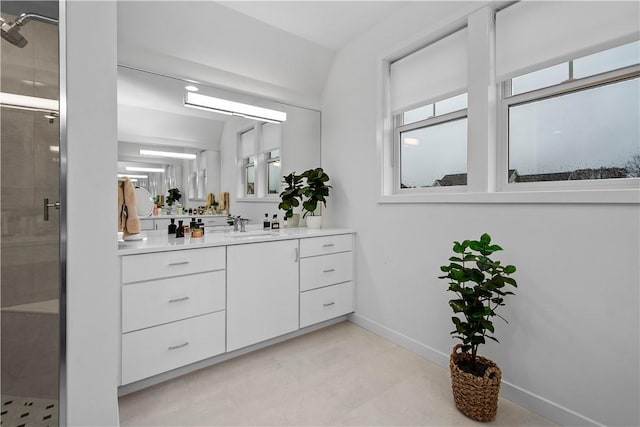 bathroom featuring baseboards, vanity, and a shower stall