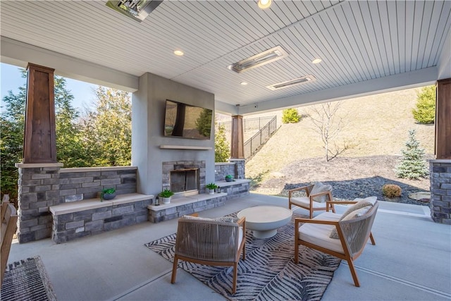 view of patio / terrace featuring fence and an outdoor stone fireplace