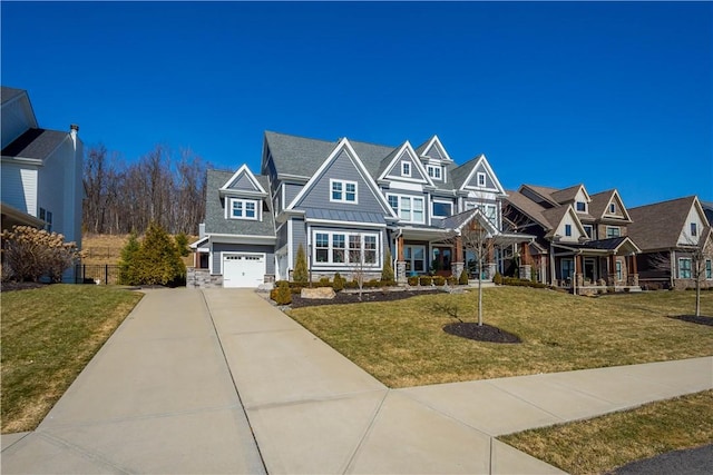 view of front of home featuring a standing seam roof, concrete driveway, a front yard, an attached garage, and metal roof