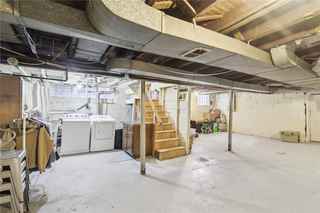 unfinished basement with visible vents, stairs, and separate washer and dryer