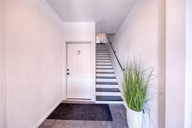 stairs featuring tile patterned floors and baseboards