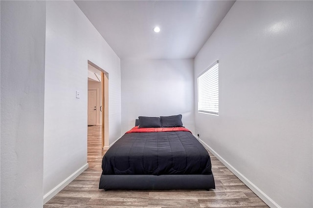 bedroom with baseboards and wood finished floors