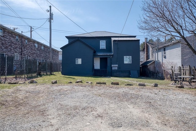 view of front facade featuring a front yard, fence, and metal roof