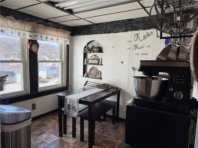 dining space with baseboards and stone finish flooring