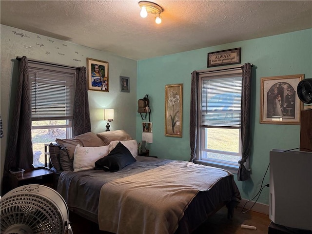 bedroom featuring wood finished floors and a textured ceiling