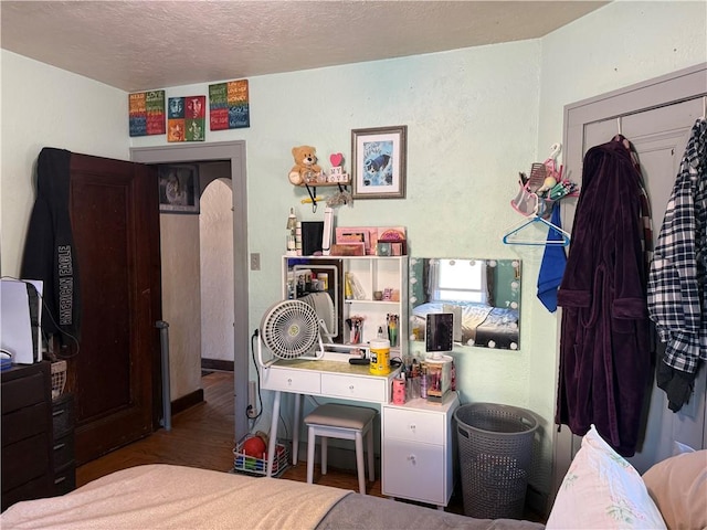 bedroom with a textured ceiling and wood finished floors