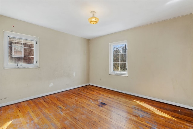 unfurnished room featuring baseboards and hardwood / wood-style floors