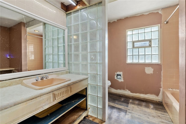 bathroom with toilet, wood finished floors, a shower, a bath, and vanity