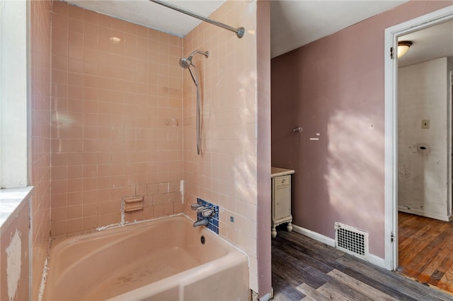 bathroom with visible vents, baseboards, shower / bath combination, and wood finished floors