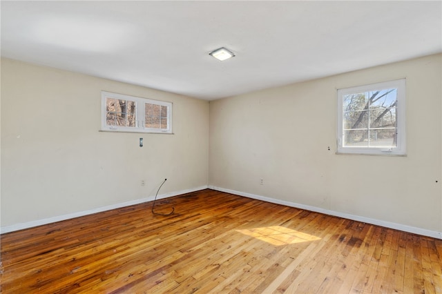 unfurnished room with baseboards and hardwood / wood-style flooring