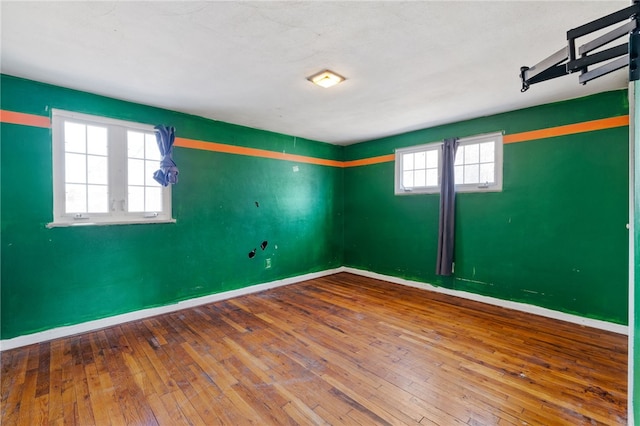 unfurnished room featuring baseboards and hardwood / wood-style floors