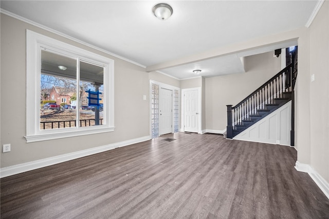 unfurnished living room featuring stairway, wood finished floors, baseboards, visible vents, and crown molding