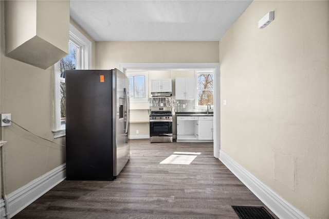 kitchen with plenty of natural light, appliances with stainless steel finishes, white cabinetry, and visible vents