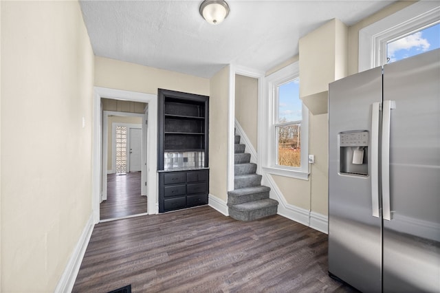 kitchen featuring baseboards, dark wood-style floors, and stainless steel fridge with ice dispenser