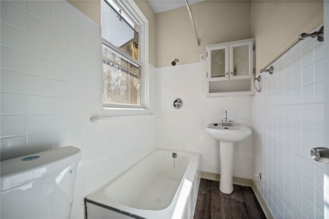 bathroom with toilet and tile walls