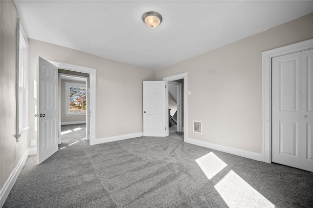 unfurnished bedroom featuring carpet flooring, visible vents, and baseboards