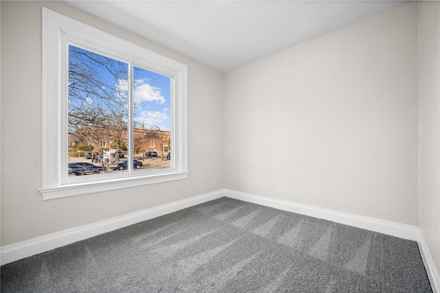 carpeted spare room featuring baseboards