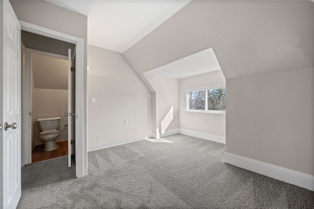 additional living space featuring carpet floors, baseboards, and vaulted ceiling