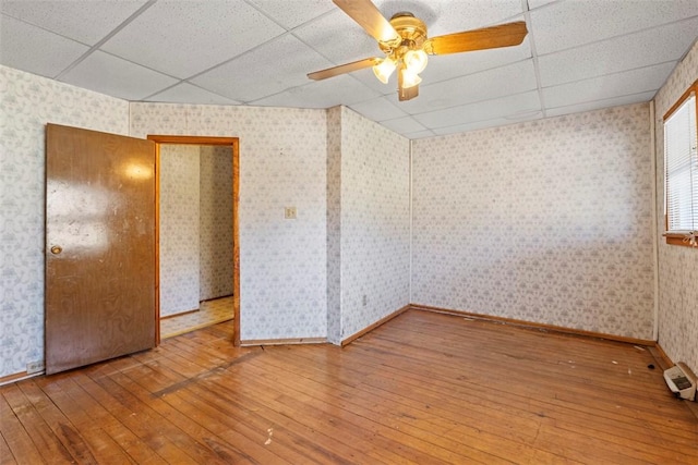 unfurnished room with wallpapered walls and a drop ceiling