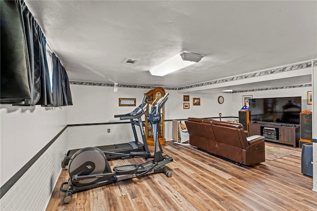 workout area with visible vents and light wood-type flooring