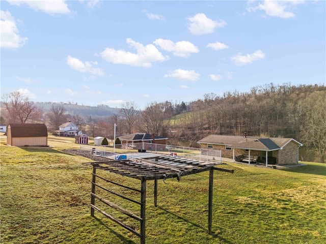 view of yard featuring a storage shed, an outbuilding, and fence