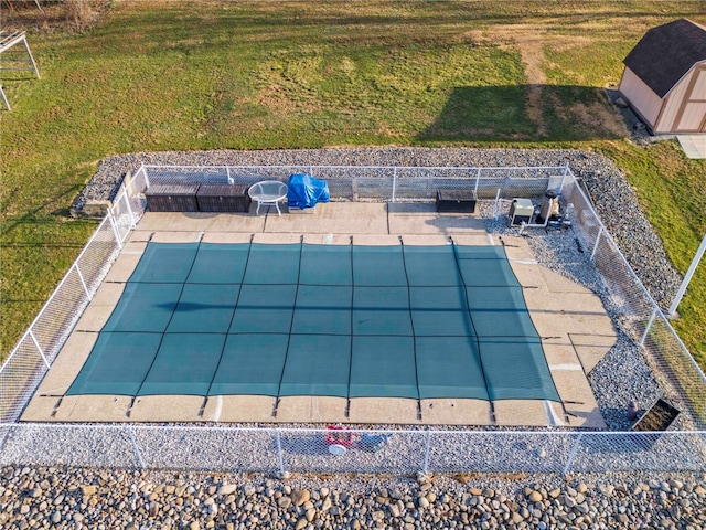 view of pool featuring a patio, fence, and a lawn