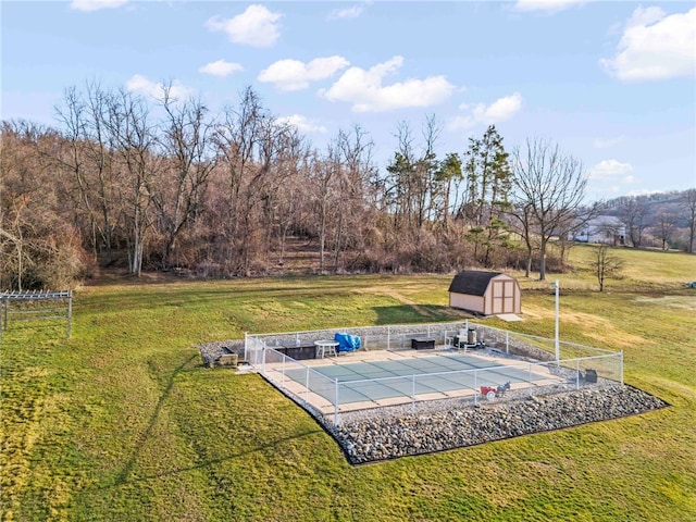 view of yard featuring an outbuilding, a patio area, a fenced in pool, and a shed