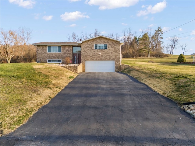 split foyer home featuring a front lawn, an attached garage, and aphalt driveway