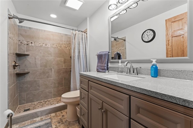 bathroom with vanity, toilet, recessed lighting, and a tile shower