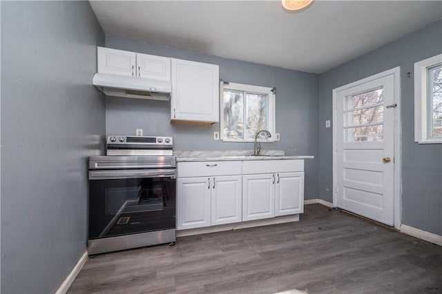 kitchen with under cabinet range hood, plenty of natural light, stainless steel range with electric stovetop, and a sink