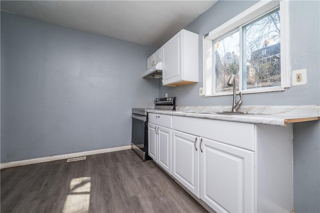 kitchen featuring dark wood-type flooring, baseboards, stainless steel range with electric cooktop, white cabinets, and a sink