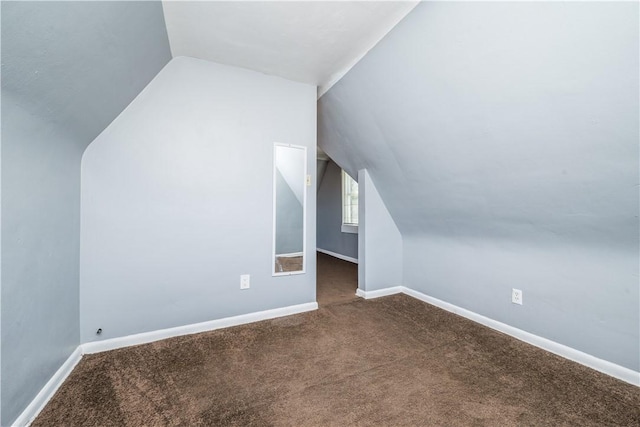 additional living space with baseboards, lofted ceiling, and carpet