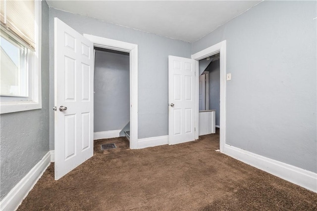 unfurnished bedroom featuring baseboards, visible vents, and carpet floors