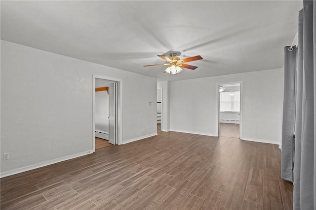 empty room featuring a baseboard heating unit, ceiling fan, and wood finished floors