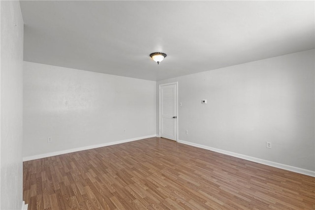 empty room with wood finished floors and baseboards