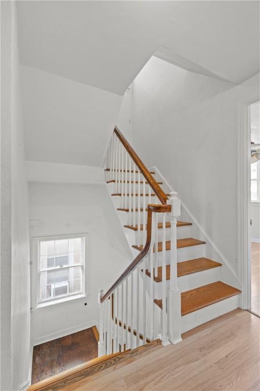 stairway featuring wood finished floors and vaulted ceiling