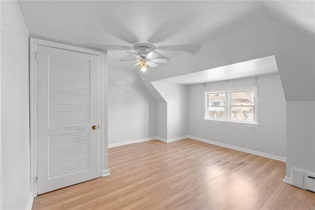 bonus room with baseboards, vaulted ceiling, a ceiling fan, and light wood finished floors