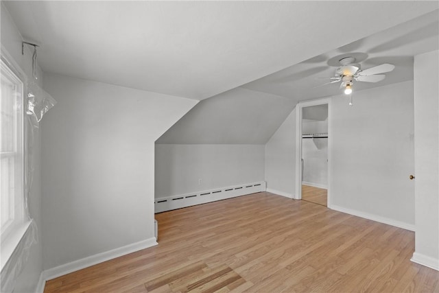 bonus room featuring wood finished floors, a ceiling fan, baseboards, vaulted ceiling, and a baseboard heating unit