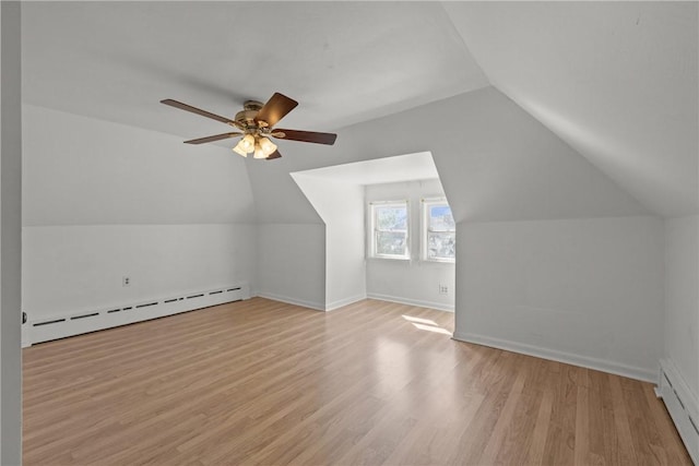 additional living space with light wood finished floors, baseboards, a baseboard heating unit, and a ceiling fan