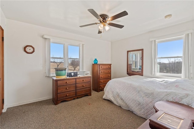 bedroom with light colored carpet, baseboards, and ceiling fan