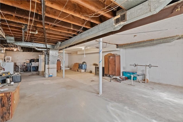 unfinished basement featuring water heater and visible vents