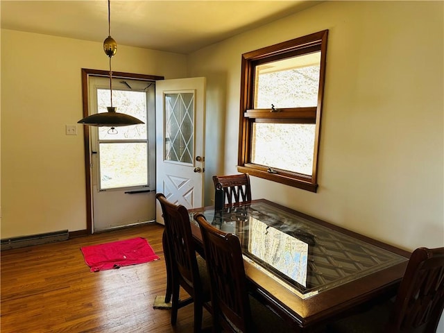 dining room with wood finished floors and a healthy amount of sunlight