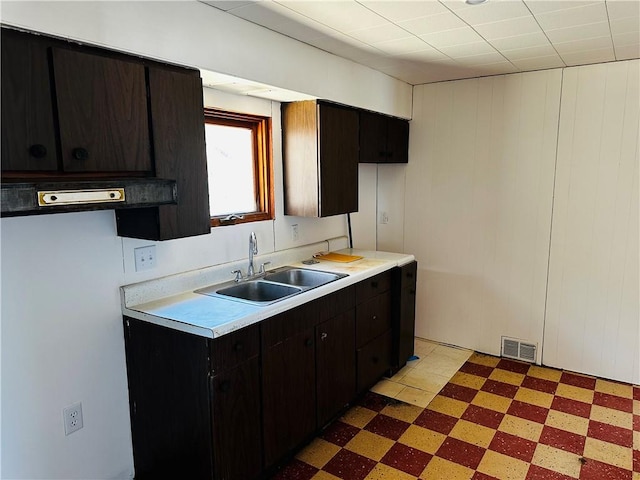 kitchen with a sink, visible vents, light floors, and light countertops