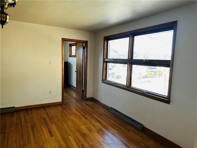 spare room featuring dark wood-style floors, visible vents, a notable chandelier, and baseboards