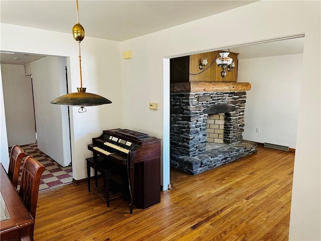 living room with visible vents, a fireplace, baseboards, and wood finished floors