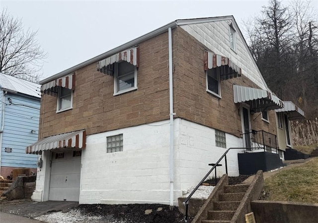 rear view of property featuring an attached garage