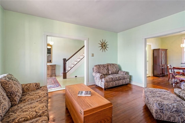 living area with hardwood / wood-style floors, stairs, and baseboards